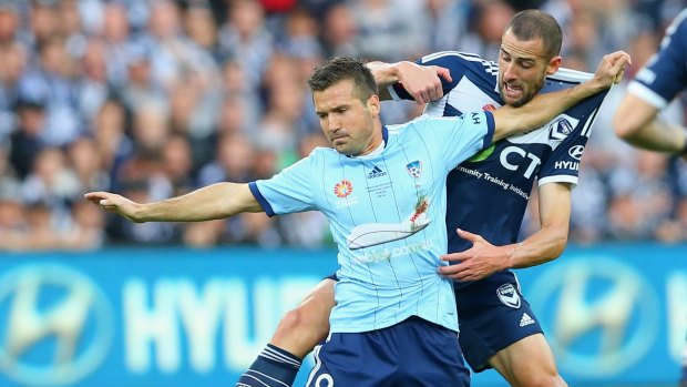 At close quarters: Milos Dimitrijevic and Carl Valeri compete for the ball during the 2015 A-League Grand Final.