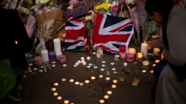A British flag is seen next to flowers after a vigil in Albert Square, Manchester.