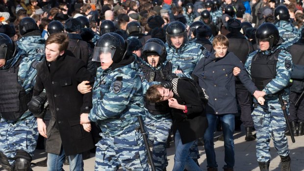 Police arrest young protesters in downtown Moscow at Sunday's protest.