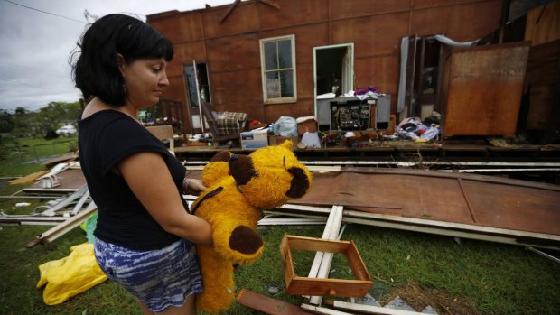 Melanie Cobb holds her childhood teddy bear she retrieved from her grandmother's damaged home after Cyclone Marcia hit the coastal town of Yeppoon.
