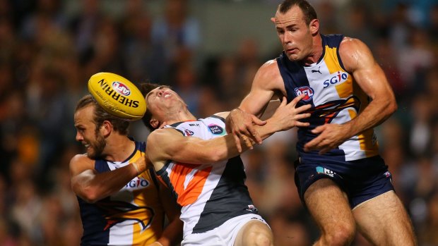 Jeremy Cameron of the Giants (centre) is struck on the nose in a marking contest with Will Schofield and Shannon Hurn of the Eagles.