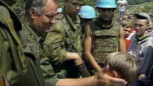 Bosnian Muslim boy Izudin Alic is patted on the head by Ratko Mladic in 1995 as Mladic assures him that everyone in Srebrenica would be safe.