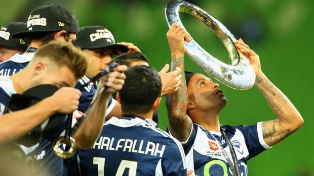 Archie Thompson holds the A-League championship trophy after Melbourne Victory's 3:0 grand final win against Sydney FC.