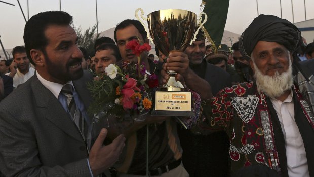 Afghan cricket team captain Mohammad Nabi Esa Khil (centre) holds the ACC Cup after the team's arrival in Kabul which qualified them for the World Cup.