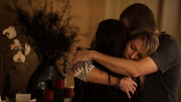 Aaron Short's parents and girlfriend embrace in mourning in front of a shrine in their family home.