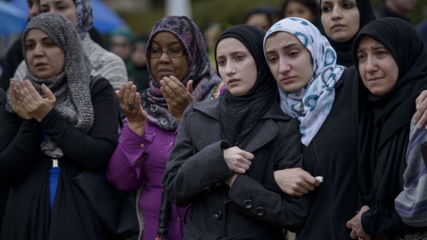 Mourners listen to a funeral prayer during the ceremony. 