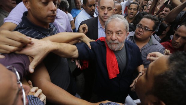 Brazil's former president Luiz Inacio Lula da Silva surrounded by supporters as he leaves the Workers' Party building in Sao Paulo, Brazil, on Friday.