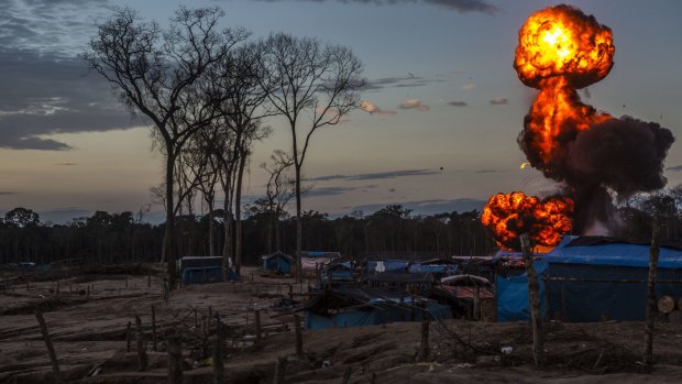 Flames rise into the sky at an illegal gold mining camp inside the Amazonian National Reserve.