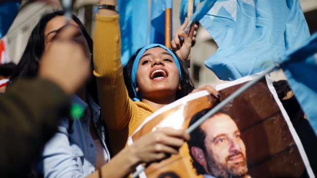 A girl chants slogans as she holds a picture of Lebanese Prime Minister Saad Hariri outside his residence in Beirut the day after his return.