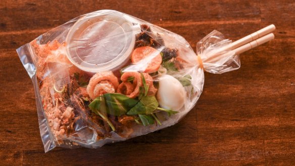 The rice paper salad is delivered in a plastic bag with a set of chopsticks.