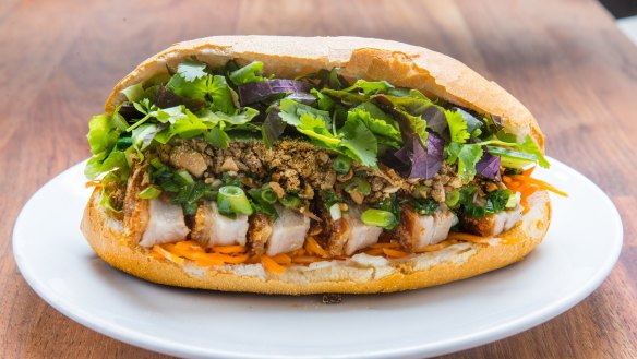 Pork belly banh mi with red curry paste, crunchy chilli oil and plenty of herbs.