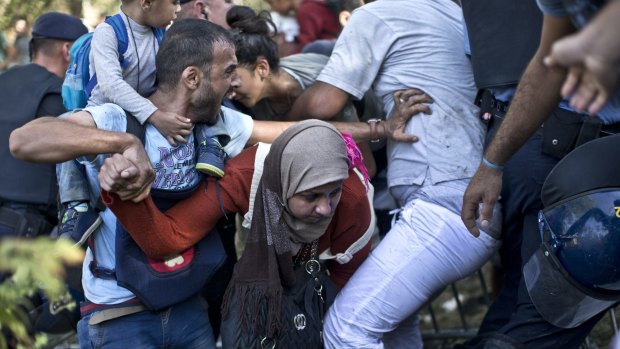 A woman is trampled as migrants and refugees push through police lines in Tovarnik, Croatia, on Thursday.
