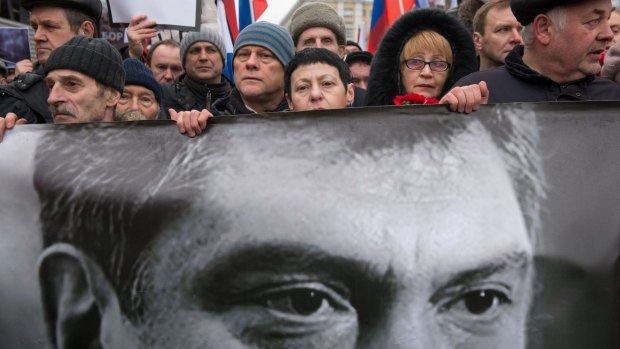 Marchers carry a banner bearing a portrait of Boris Nemtsov.