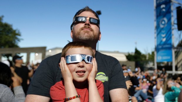 Dan Blanchette and his son, Sam, 6, watch the final phases of a total solar eclipse in Salem, Oregon. 