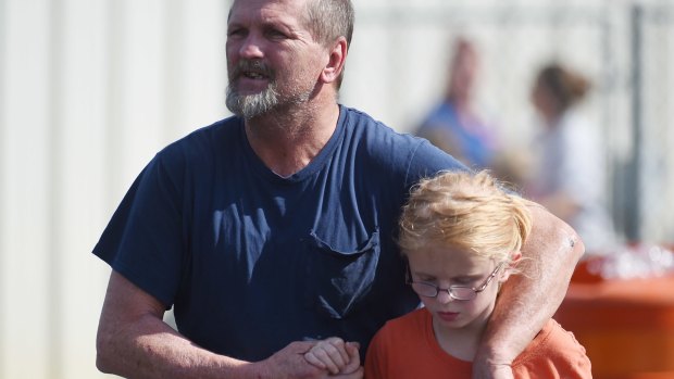 Joey Taylor walks with his daughter Josie after picking her up in Townville on Wednesday.