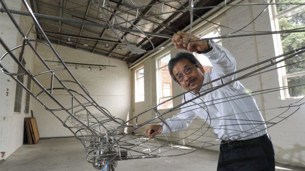 Japanese artist Kozo Nishino finishes off his sculpture <i>breezing in Canberra.</i>