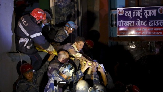 Rishi Khanal is taken out of a collapsed building by police and the French rescue team.