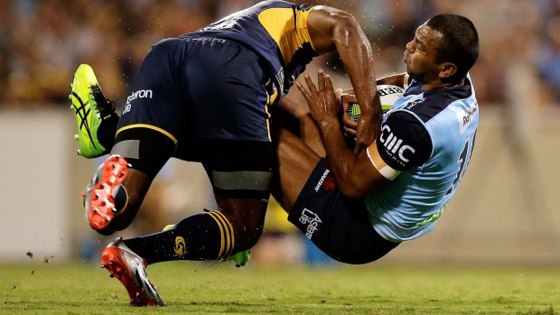Down you go: Kurtley Beale of the Waratahs is upended by Tevita Kuridrani of the Brumbies.