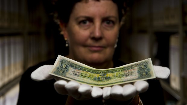 One worth a million: NLA Curator of Manuscripts Kylie Scroope holds the rare one pound.