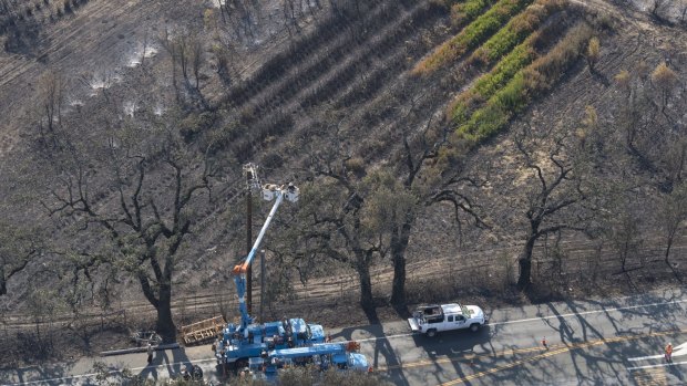 Pacific Gas and Electric Co. carry out repairs in Santa Rosa after officials said a downed power line may have sparked the blaze.