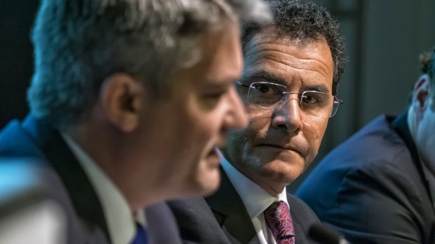 Price cap of $2 a share for retail investors: Mathias Cormann and Medibank managing director George Savvides at the Melbourne Convention and Exhibition Centre.