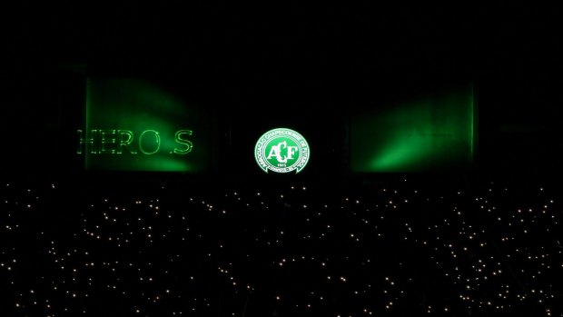 Mobile phone flashlights are used by fans to pay tribute to Chapecoense Real players killed in Monday's plane crash in Colombia. In green, the word "herois" (heroes) is misspelt by a lighting malfunction.