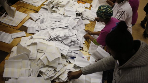 Election officials start the ballot counting process at a polling station on the outskirts of Cape Town.