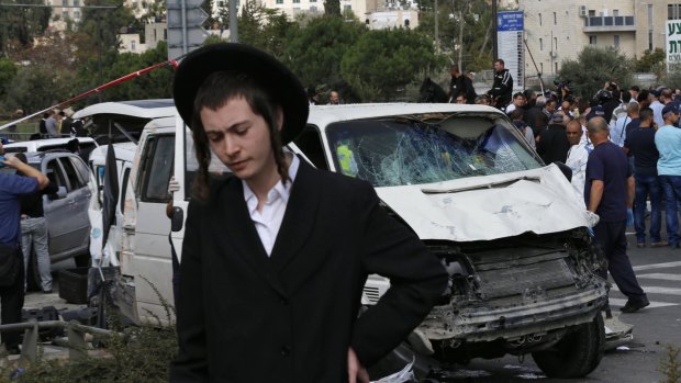 A Jewish man walks past the van used by a Palestinian motorist to ram into pedestrians in Jerusalem.