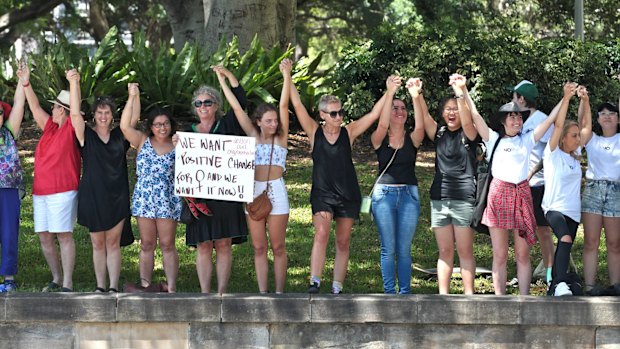 Hundreds join hands to cheer as part of the "Unbroken" women's march.