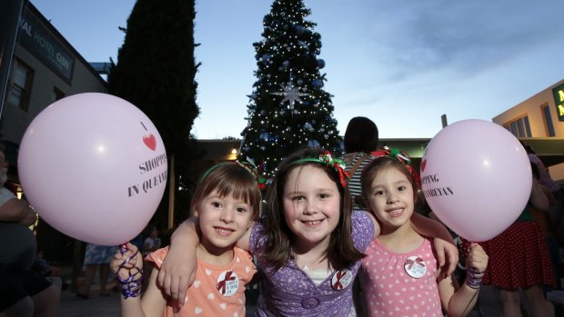 From left, Ava Kenningham, 5, Madison Lloyd, 7, and Olivia Kenningham, 5, all of Queanbeyan, in front of the Christmas tree in Crawford Street.