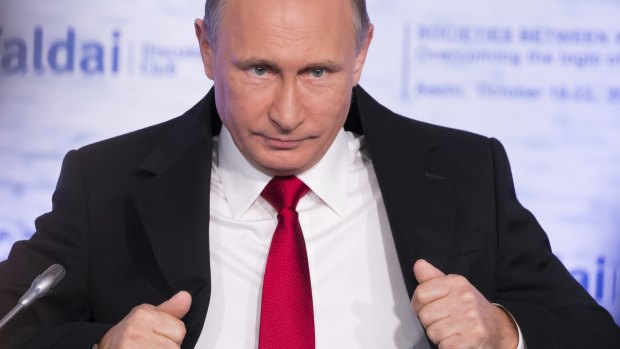 Russian President Vladimir Putin corrects his jacket last month. 