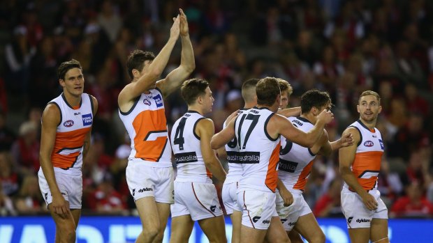 Lachie Whitfield of the Giants celebrates with teammates after scoring a major.