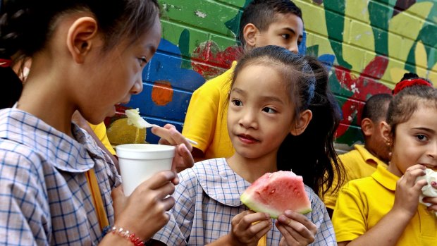 Cabramatta Public School children eat rice pudding and watermelon supplied by Foodbank.