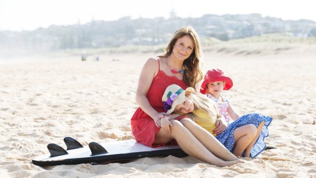 Entrepreneur Emily Carding with daughters Violet, left, and Holly on North Curl Curl Beach. 