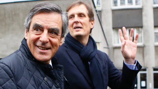 Fillon, left, leaves his campaign headquarters after delivering a speech in Paris.