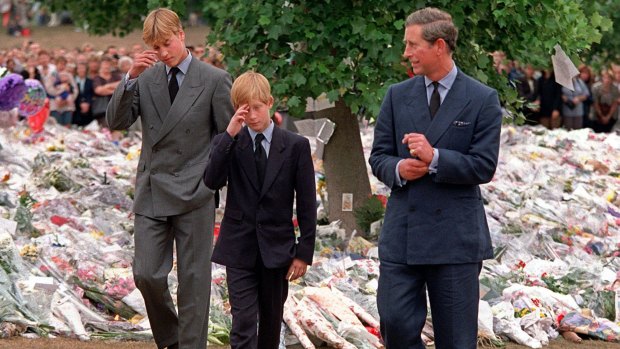 Princes William and Harry with their father Prince Charles walk among floral tributes in the wake of Diana's death. 