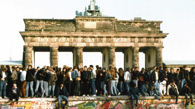 Germans from East and West stand on the Berlin Wall, one day after the wall opened in 1989.