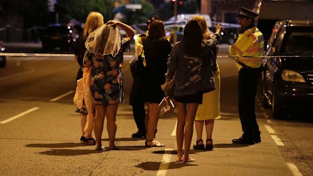 People talk to police officers at a cordon as they tried to find their way back to where they were staying after an attack in London.