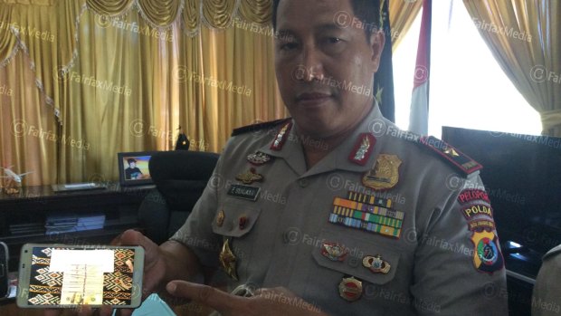 General Endang Sunjaya, police chief of East Nusa Tenggara province, shows a mobile phone with a picture of the money allegedly paid to people smugglers by Australia in June this year.
