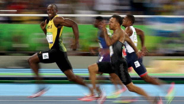 Smile for the camera: Usain Bolt competes in the men's 100m semi-final.
