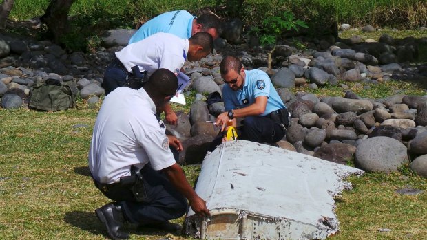 French police inspect the flaperon, now confirmed to be from MH370, on Reunion Island.