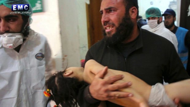 This picture, provided by the Syrian anti-government activist group Edlib Media Center,  shows a man carrying a child following the chemical attack, at a makeshift hospital in the town of Khan Sheikhoun.