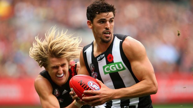 Magpies captain Scott Pendlebury is tackled by Dyson Heppell.