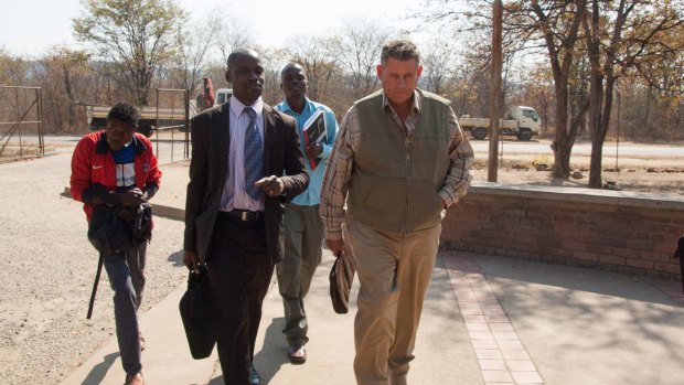 Theo Bronkhorst, right, a professional hunter, arrives for his appearance at the magistrates courts in Hwange, Zimbabwe, in July 2015.