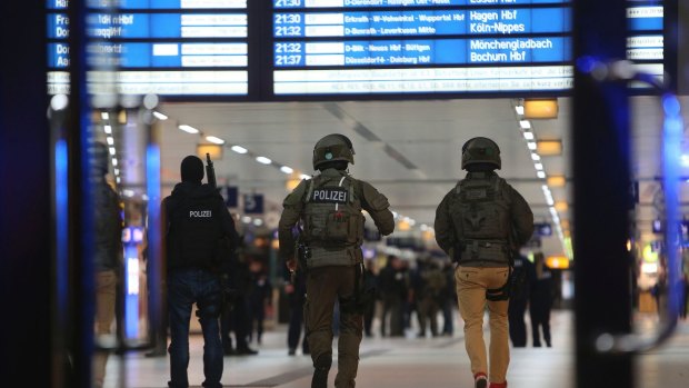 Special police forces walk into the main train station in Dusseldorf following an axe attack. 