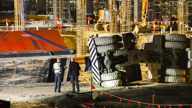 Police, ambulance, and worksafe staff at the UC hospital building site where a crane was lying on its side.