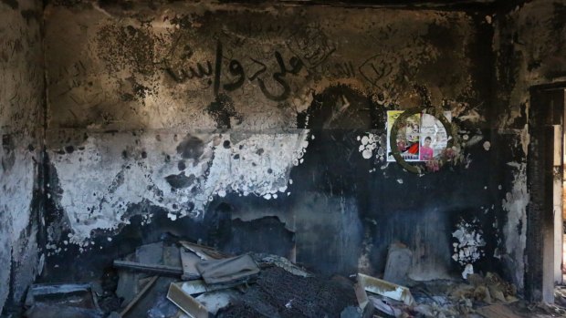 A child's burnt clothing and belongings can still be seen on the floor of the Dawabshe family home. Ali Dawabshe's name is written in Arabic on the wall.