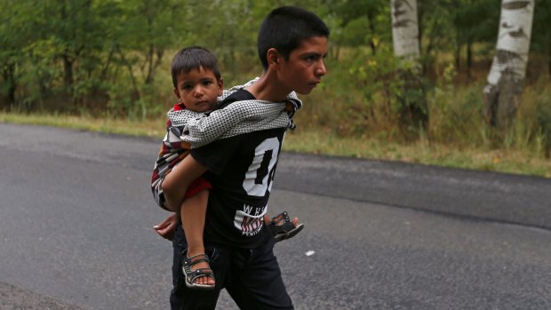 Afghan children walk down a road after crossing the border illegally from Serbia.