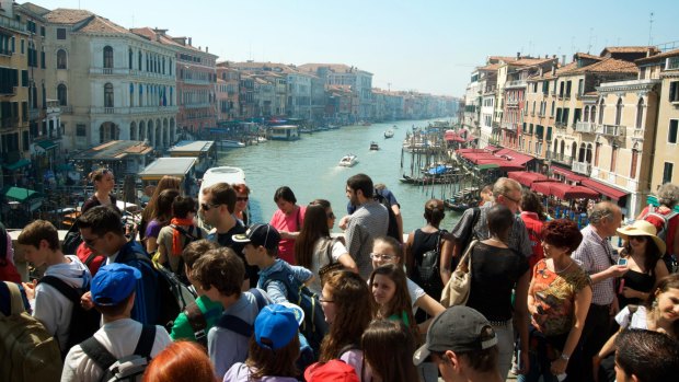 Crowds of tourists on the Rialto Bridge in Venice.