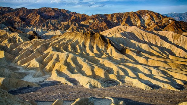 The sun rises over Zabriskie Point in Death Valley National Park, California.